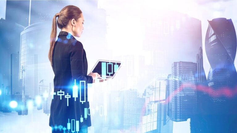 serious young businesswoman using laptop in abstract city with double exposure of blurry financial graph